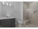 Modern bathroom with a glass shower, elegant gray vanity, and stylish gold hardware at 7621 Wingfoot Dr, Raleigh, NC 27615