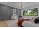 Inviting main bedroom boasts an accent wall, chic decor, and scenic backyard view at 7621 Wingfoot Dr, Raleigh, NC 27615