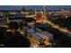This nighttime aerial view shows modern townhomes near a baseball field and the brightly lit city skyline at 777 Willard St, Durham, NC 27701