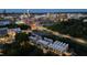 This nighttime aerial view shows townhomes near a lit-up baseball field and the distant city skyline at 777 Willard St, Durham, NC 27701