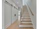 Hallway with wood floors, staircase, and sliding barn doors at 777 Willard St, Durham, NC 27701