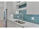 Modern kitchen featuring white cabinets, stainless steel appliances, and a blue tile backsplash at 777 Willard St, Durham, NC 27701