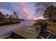 Wooden dock features a chair overlooking the serene lake and colorful sky at 79 Cove Lndg, Sanford, NC 27332