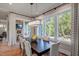 Bright dining room with large windows, dark wood table, stylish chairs, and modern chandelier at 83 Stickleback Dr, Willow Springs, NC 27592