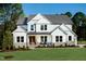Stunning new two-story white home with beautiful stone accents and professionally landscaped front yard at 83 Stickleback Dr, Willow Springs, NC 27592