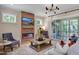 Cozy living room featuring a brick fireplace, modern lighting, and access to the screened porch at 83 Stickleback Dr, Willow Springs, NC 27592