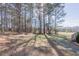 Natural backyard area with scattered trees and a stone paver pathway leading into the wooded area at 10 Georgetown Woods Dr, Youngsville, NC 27596