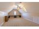 Spacious bonus room with built-in desk, carpet, ceiling fan, and natural light from window and skylight at 10 Georgetown Woods Dr, Youngsville, NC 27596