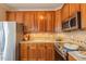 Kitchen with stainless steel appliances, tile backsplash, and wooden cabinets at 10 Georgetown Woods Dr, Youngsville, NC 27596