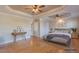 Bright main bedroom featuring hardwood floors, tray ceilings with ceiling fans, and a walk-in closet at 10 Georgetown Woods Dr, Youngsville, NC 27596