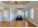 Bright main bedroom featuring hardwood floors, tray ceilings with ceiling fans, and a walk-in closet at 10 Georgetown Woods Dr, Youngsville, NC 27596