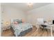 Cozy bedroom features wood flooring, a bed with colorful floral comforter, and a white writing desk at 1101 Bessie Ct, Wake Forest, NC 27587