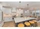 Modern kitchen with a large island, white cabinets, stainless steel appliances, and stylish pendant lighting at 1101 Bessie Ct, Wake Forest, NC 27587