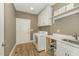 The laundry room features modern white cabinets, a stainless steel sink, and updated washer and dryer at 1101 Bessie Ct, Wake Forest, NC 27587