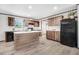 Well-lit kitchen featuring wood grain cabinets, modern appliances, and a convenient island with a white countertop at 112 Mckoy Town Rd, Cameron, NC 28326