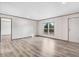 Well-lit, open living space with light wood floors and white walls, with a view to the outdoors through two windows at 112 Mckoy Town Rd, Cameron, NC 28326