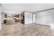 Bright, open living space with gray wood-look floors adjacent to kitchen with wood grain cabinets and black refrigerator at 112 Mckoy Town Rd, Cameron, NC 28326