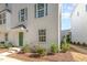 Charming exterior of a townhome featuring a green door, neat landscaping, and large windows at 113 Callowhill Ln, Durham, NC 27713