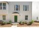 Charming exterior of a townhome featuring a green door, neat landscaping, and large windows at 113 Callowhill Ln, Durham, NC 27713