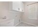 Bright laundry room with tile flooring, and cabinets for storage and organization at 113 Callowhill Ln, Durham, NC 27713