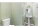 Charming powder room featuring a pedestal sink, rounded mirror, and a toilet at 113 Callowhill Ln, Durham, NC 27713