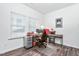 Functional home office space with desk, chair, storage, and natural light from two windows at 117 Blue Hydrangea Ln, Holly Springs, NC 27540