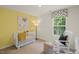 Bright Bedroom with a white crib, rocking chair, and adorable dog artwork at 135 Scenic Rock Dr, Youngsville, NC 27596