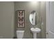 Stylish powder room features an oval mirror, pedestal sink, and butterfly artwork at 135 Scenic Rock Dr, Youngsville, NC 27596