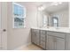 Bright bathroom featuring a double vanity with grey cabinets and a large window providing natural light at 1430 Rosepine Dr, Cary, NC 27519