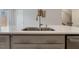 Close-up of a kitchen island featuring a sink, modern faucet, and gray cabinets at 1430 Rosepine Dr, Cary, NC 27519