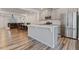 Open concept kitchen with a white island, stainless steel appliances, and hardwood floors at 1430 Rosepine Dr, Cary, NC 27519