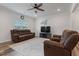 Bright living room with hardwood floors, ceiling fan, and comfortable brown couches at 1430 Rosepine Dr, Cary, NC 27519