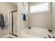 Bathroom with a soaking tub, glass shower door, and bright natural lighting at 156 Bornean Dr, Garner, NC 27529