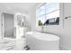 Bright, spacious bathroom with a soaking tub, white marble floors, and large window with view at 162 Lookout Rdg # 677, Pittsboro, NC 27312
