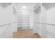 Large, empty walk-in closet with custom white shelves, drawers, and wood flooring at 162 Lookout Rdg # 677, Pittsboro, NC 27312