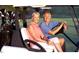 A smiling couple is driving a golf cart on the green at 162 Lookout Rdg # 677, Pittsboro, NC 27312