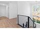 Bright hallway with wood floors, white walls, modern railing, and large window providing natural light at 162 Lookout Rdg # 677, Pittsboro, NC 27312