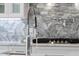 Close-up of a kitchen sink with a chrome faucet, marble countertops, and a tiled backsplash at 162 Lookout Rdg # 677, Pittsboro, NC 27312