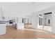 Open-concept living space with hardwood floors, island kitchen, and access to screened porch at 162 Lookout Rdg # 677, Pittsboro, NC 27312