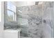 Bathroom shower featuring elegant marble-like tile, glass enclosure, and a built-in bench for a spa-like experience at 162 Lookout Rdg # 677, Pittsboro, NC 27312