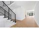 Open staircase with black metal railings and wood stairs with a view to the living room at 162 Lookout Rdg # 677, Pittsboro, NC 27312
