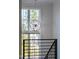 Close up of window with view and a modern chandelier in a hallway with stairs and a dark metal railing at 162 Lookout Rdg # 677, Pittsboro, NC 27312