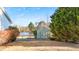 View of a backyard with a storage shed with a lake view on a sunny day at 186 Sunrise Dr, Sanford, NC 27332