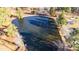 Scenic aerial view of a tranquil pond surrounded by lush trees and verdant landscape at 186 Sunrise Dr, Sanford, NC 27332