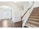 Welcoming entryway with wood floors and a carpeted staircase, complemented by a decorative glass door at 1951 Mostyn Ln, Apex, NC 27502