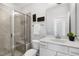 Well-lit bathroom featuring a tiled shower with glass door, white vanity, and decorative wall art at 200 Gravel Brook Ct, Cary, NC 27519