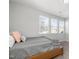 Bedroom featuring neutral decor, a wooden bed frame, and natural light from three large windows at 200 Gravel Brook Ct, Cary, NC 27519