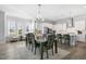 Bright dining area with modern chandelier opens to a white kitchen and sunroom at 200 Gravel Brook Ct, Cary, NC 27519