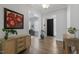 Welcoming foyer with a black front door, hardwood floors, and a decorative cabinet topped with vibrant floral art at 200 Gravel Brook Ct, Cary, NC 27519
