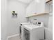 Functional laundry room with modern washer and dryer, complemented by upper cabinets at 200 Gravel Brook Ct, Cary, NC 27519